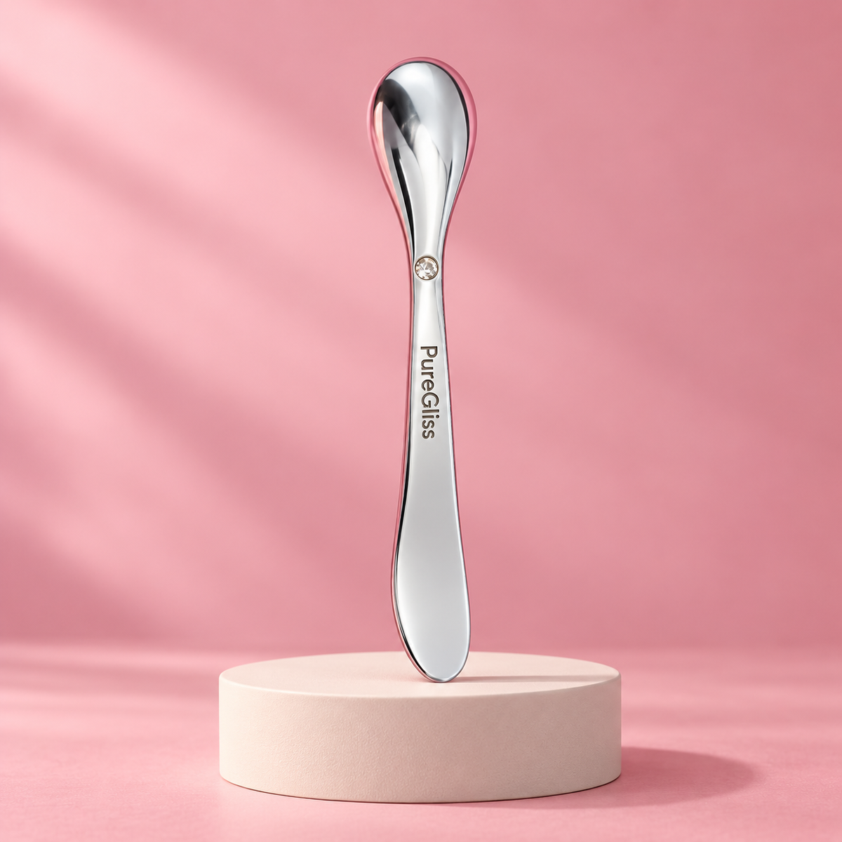 Applicateur Soin Visage Métal PureGliss — mise en scène sur socle