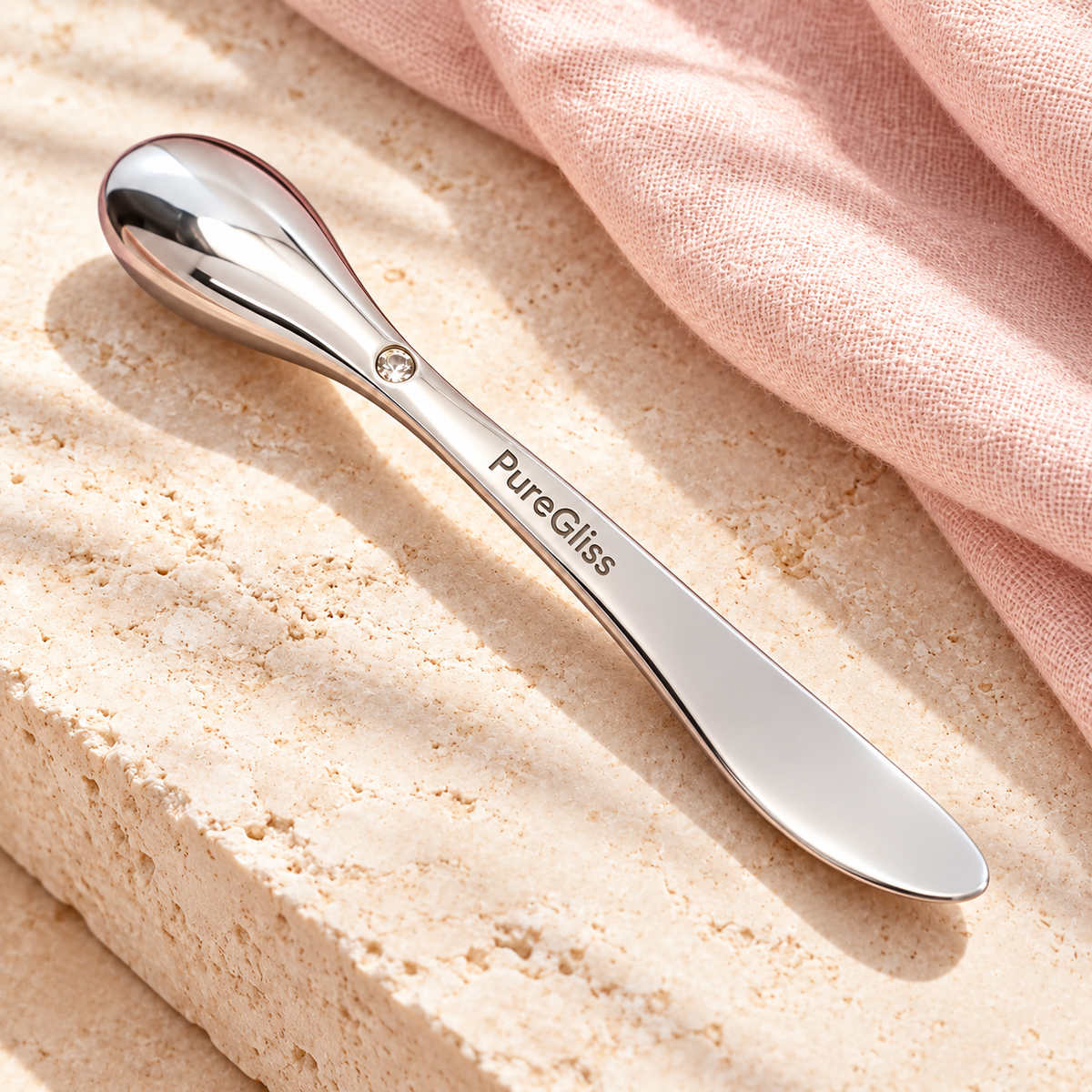 Applicateur Soin Visage Métal PureGliss — vue dans un décor de pierre et de lin